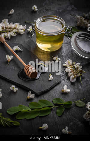 Akazienblüten und natürlichem Honig im Glas Stockfoto