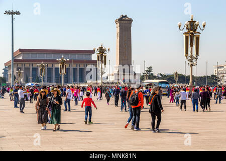 Das Denkmal für die Helden des Volkes ragt über Besucher auf dem Platz des Himmlischen Friedens. Dahinter steht das Mausoleum von Mao Zedong. Peking, China. Stockfoto