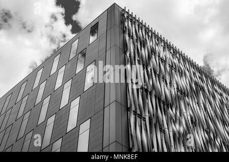 Ein schwarz-weiß Bild suchen, um sich in eine moderne Stadt Büro Gebäude gegen einen bewölkten Himmel in London Stockfoto