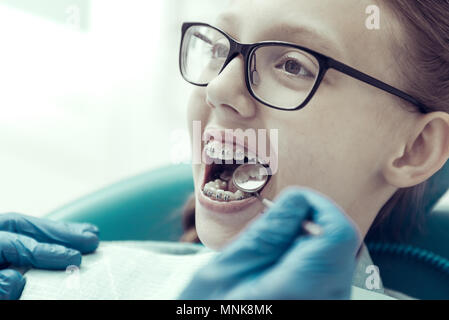 Mädchen in Gläser in einem Zahnarzt Klinik sitzen Stockfoto
