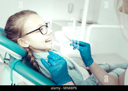 Süße Mädchen in geschweiften Klammern am Zahnarzt suchen Stockfoto