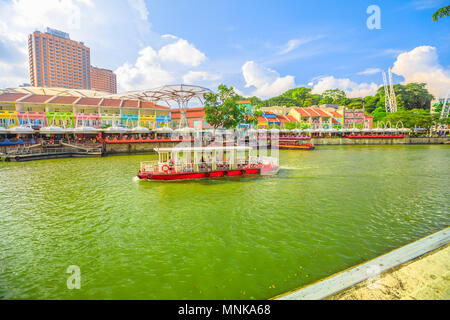 Turistic Bootsfahrt auf dem Singapore River am Clarke Quay und Riverside an einem sonnigen Tag mit blauen Himmel. Singapur, Südostasien. Stockfoto