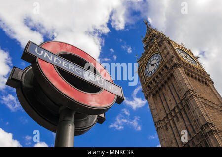 LONDON, Großbritannien - 11 August, 2013; das Zeichen der Londoner U-Bahn und den Big Ben am U-Bahnhof Westminster in London. Stockfoto