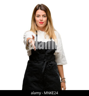 Shop Besitzer Frau mit Schürze hält Hände einladend im Handshake darstellen, Vertrauen und Erfolg Konzept, Begrüßung Stockfoto