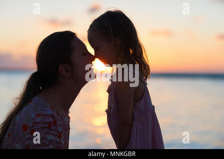 Silhouetten von Mutter und Tochter bei Sonnenuntergang Stockfoto