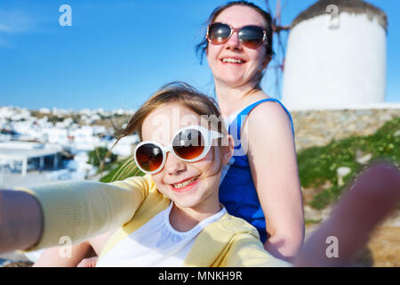 Glückliche Familie Mutter und ihre süßen kleinen Tochter auf den Urlaub nimmt selfie auf Klein Venedig Bereich auf der Insel Mykonos, Griechenland Stockfoto