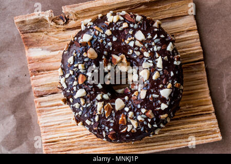Schokolade Donut mit gewürfelten Haselnuss Stücke. Dessert Konzept. Stockfoto