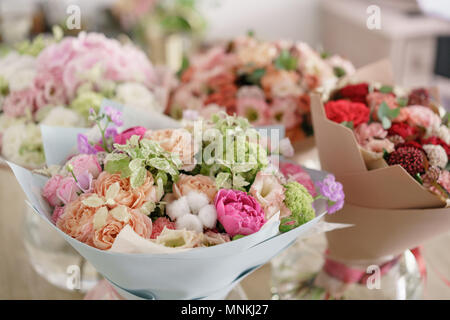 Floristik Konzept. Vier Bouquet von schönen Blumen auf grau Tabelle. Frühling Farben. Die Arbeit der Florist in einem Blumenladen. Stockfoto