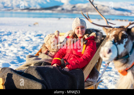 Familie der Mutter und ihrer Tochter auf Rentier Safari auf sonnigen Wintertag im nördlichen Norwegen Stockfoto