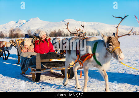 Familie der Mutter und ihrer Tochter auf Rentier Safari auf sonnigen Wintertag im nördlichen Norwegen Stockfoto