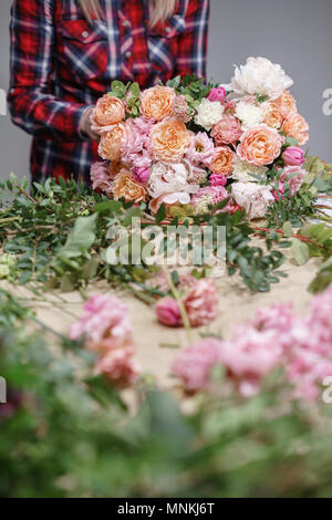 Weibliche Florist. Florale Werkstatt - Frau, die eine schöne Blume Komposition einen Blumenstrauß. Floristik Konzept Stockfoto