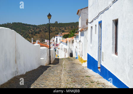 Die gemütliche gepflasterte Gassen mit weiß Alentejo rustikale Häuser innerhalb der alten Stadtmauern von Mértola. Baixo Alentejo. Portugal Stockfoto