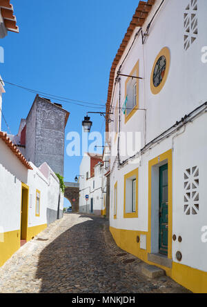 Der Blick auf die gepflasterte Straße von Evora mit der gemütlichen weißen Häusern. Evora. Alentejo. Portugal Stockfoto