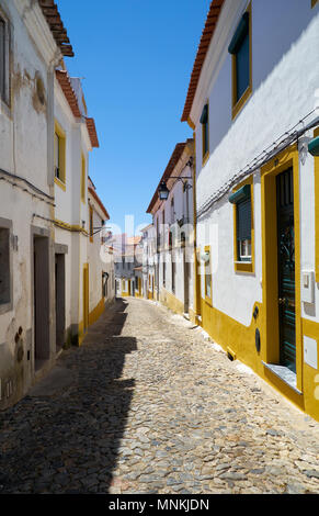 Der Blick auf die gepflasterte Straße von Evora mit der gemütlichen weißen Häusern. Evora. Alentejo. Portugal Stockfoto