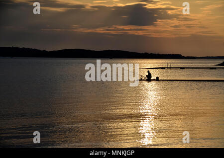 Sonnenuntergang an der Adria mit den Fischern und den Brijuni Inseln im Hintergrund Stockfoto