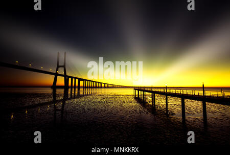 Golden Hour an der spektakulären Vasco da Gamma Brücke in Lissabon. Mithilfe der Macphun Luminar 2018 Sonnenstrahlen Filter bearbeitet werden. Stockfoto