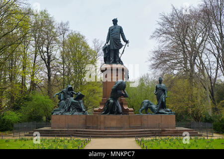 Berlin, Deutschland - 14 April 2018: Memorial Statue an Prinz Otto von Bismarck mit Blumen und Grünes Gras im Vordergrund und Bäume auf. Stockfoto