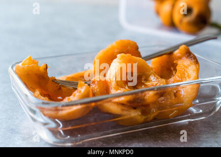 In Scheiben geschnitten Loquat Schichten bereit zu Essen mit Gabel. Ökologische Lebensmittel. Stockfoto