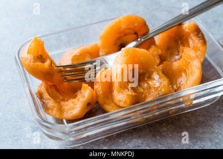 In Scheiben geschnitten Loquat Schichten bereit zu Essen mit Gabel. Ökologische Lebensmittel. Stockfoto