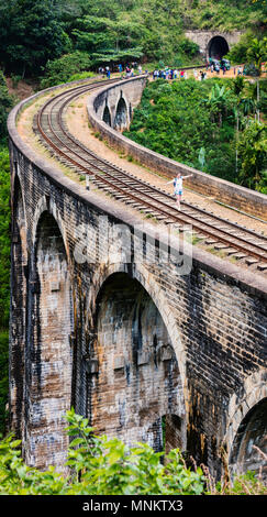 Spektakuläre Aussicht über Neun Bögen Brücke in Demodara eines der Wahrzeichen in Sri Lanka mit Frau zu Fuß entlang der Schienen Stockfoto