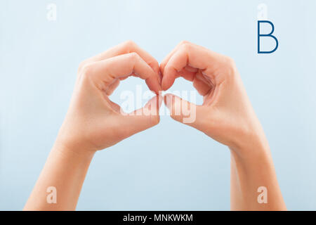 Fingerspelling Alphabet. Weibliche Hände auf blauem Hintergrund zeigen, Taubstumme BSL Buchstaben B. isoliert Stockfoto