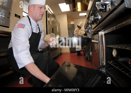 Staff Sgt. Michael Allen von Fort Bragg, N.C., Team entfernt eine Pfanne aus dem Backofen während der Streitkräfte Koch des Jahres Wettbewerb März 9. Stockfoto