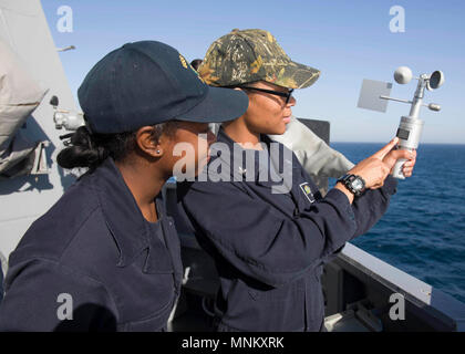 Arabischen Golf (14. März 2018) Quartermaster 2. Klasse Ashley Martindale, rechts, zeigt Quartermaster Seaman Diamond S. meistert, wie Sie einen Windmesser Windgeschwindigkeit und Richtung von der Brücke Flügel der Arleigh-Burke-Klasse zu messen geführte Anti-raketen-Zerstörer USS Preble (DDG88). Preble ist in die USA 5 Flotte Bereich für Maßnahmen zur Erhöhung der Sicherheit im Seeverkehr im Einsatz Verbündeten und Partnern zu beruhigen und der Freiheit der Schiffahrt und des freien Handels in der Region erhalten. Stockfoto