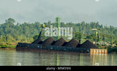 Barge ist mit über Förderband Kohle in der Vorräte am Flussufer geladen Stockfoto