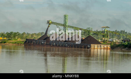 Barge ist mit über Förderband Kohle in der Vorräte am Flussufer geladen Stockfoto