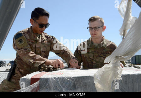 Staff Sgt. Josia McDonald (links), 455Th Expeditionary logistische Bereitschaft Squadron in-bound Cargo NCOIC und Älterer Flieger Michael Tomoiaga (rechts), 455Th ELRS Traffic Management Techniker, Prüfung in-bound cargo März 16, 2018 am Flughafen Bagram, Afghanistan. Flieger von der 455th ELRS sortieren und etwa 130 Tausend Pfund der Ladung verteilt werden jeden Monat von mehreren Standorten und Organisation. Diese Sendungen können von der Kamera Ausrüstungen für Luftfahrzeuge Teile. Stockfoto