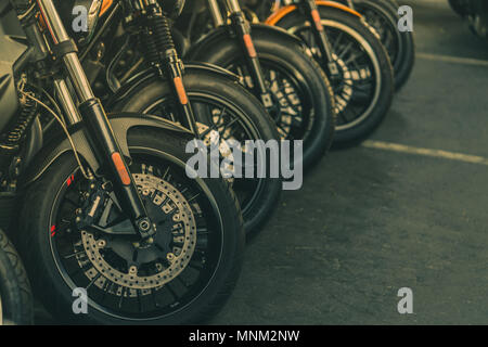 Nahaufnahme des neuen Motorrad Vorderrad. Big Bike auf dem Asphalt der Straße geparkt. Iconic Motorrad mit sportlichem Design. Schwarze Reifen mit einzigartigen Muster und Sprachen Stockfoto