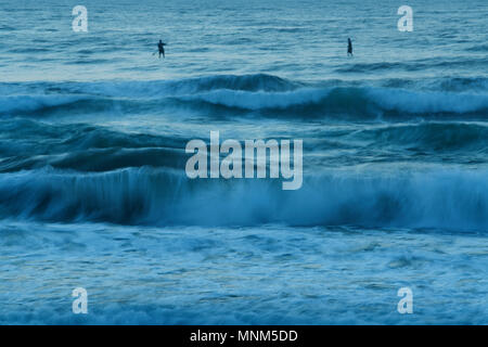 Durban, KwaZulu-Natal, Südafrika, Zahlen, zwei erwachsene Männchen auf SUP Boards paddeln, brechenden Wellen, Küstenlinie von Strand, Landschaft, blur Stockfoto