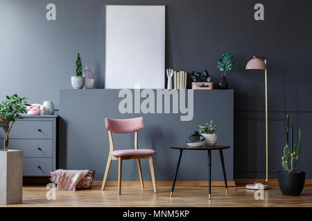 Rosa holzstuhl am Schwarzen Tisch in Grau Wohnzimmer Interieur mit Mockup von leeren Plakat Stockfoto