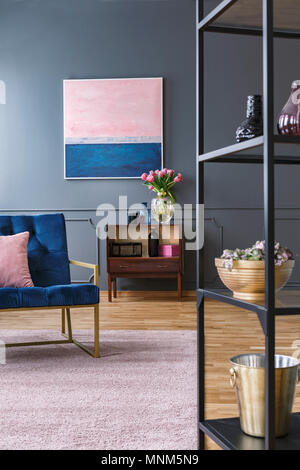 Pink und blau malen auf graue Wand über Kabinett mit Blumen im Wohnzimmer Innenraum Stockfoto