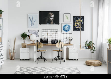Moderne home office Einrichtung mit Doppelbett, Schreibtisch, Poster und Zubehör Stockfoto