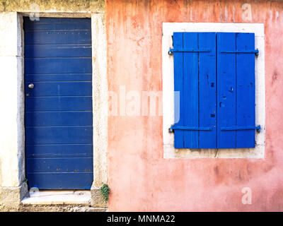 Alte rosa angemalt Gebäude mit blauer Tür und blauen Fensterläden Stockfoto