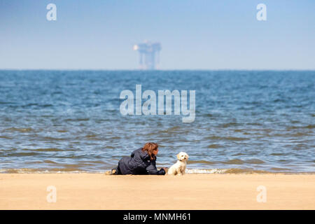 Southport, Merseyside, UK. 18 Mai, 2018. Southport, Merseyside. UK Wetter. Einen schönen sonnigen Nachmittag wie eine Frau sitzt mit ihrer besten Freundin auf den Ufern von Southport Strand in Merseyside. Credit: cernan Elias/Alamy leben Nachrichten Stockfoto