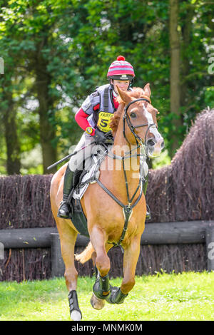 Corby, England. 18. Mai 2018. Das Pferd die echten Rebel Rebel und Reiter Stephanie Waite Galopp nach sprang ein Hindernis Zaun im cross country Event während der Internationalen horse trials im Park von Schloss Rockingham, Corby, England am 18. Mai 2018. Quelle: Michael Foley/Alamy leben Nachrichten Stockfoto