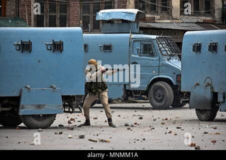 Srinagar, Kashmir. 18 Mai, 2018. Ein indischer Polizist soll seine Tablette Gewehr in Richtung Kaschmir Demonstranten (nicht dargestellt) bei Zusammenstößen in Srinagar, Kashmir. Eine große Zahl von Demonstranten nahmen an einer Kundgebung in Srinagar, die grösste Stadt der umstrittenen Himalaya Valley, folgenden Freitag, Gebete, und forderten ein Ende der israelischen Besetzung palästinensischen Landes. Die Massenkundgebung gedreht heftig, nachdem die Polizei Tränengas, Pellets und Gummigeschosse abgefeuert, die Demonstranten in Baku zu zerstreuen. Stockfoto