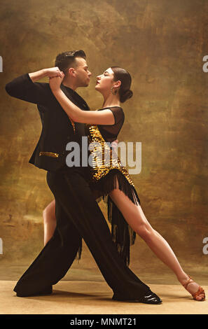 Tanz Ballroom Couple in Gold Kleid tanzen auf Studio Hintergrund. Stockfoto