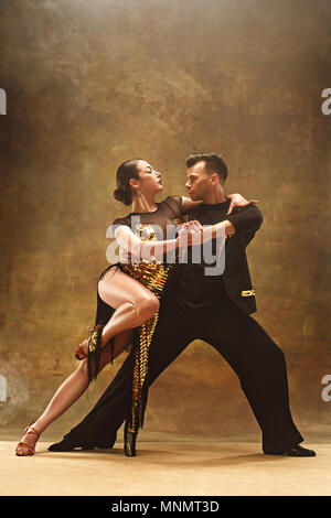 Tanz Ballroom Couple in Gold Kleid tanzen auf Studio Hintergrund. Stockfoto