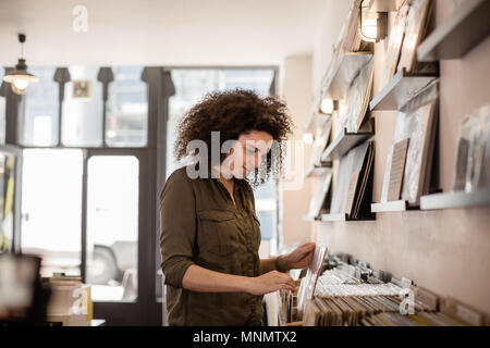 Junge Erwachsene Frauen auf der Suche nach Datensätzen in einem Store Stockfoto