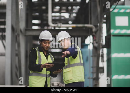 Gewerbliche Arbeitnehmer mit einem digitalen Tablet vor Ort Stockfoto