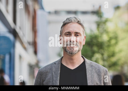 Portrait von lächelnden reifer Mann draußen in der Stadt Stockfoto