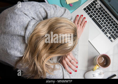 Frau schlafen auf Schreibtisch Stockfoto
