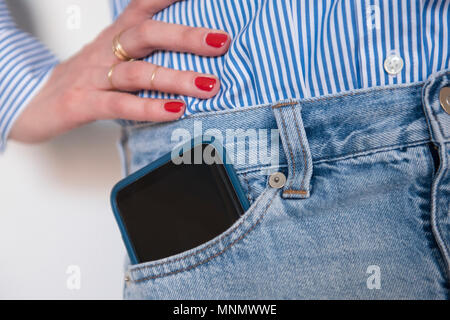 Frau mit Smartphone in Jeans Tasche Stockfoto