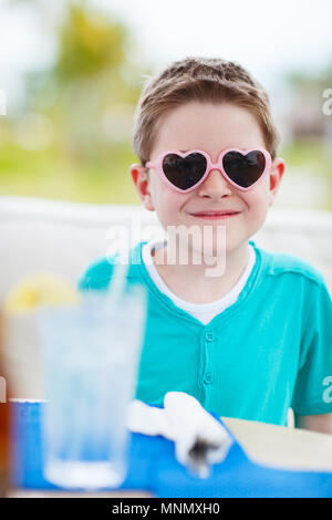 Portrait von niedlichen kleinen Jungen tragen Sonnenbrille Herzform Stockfoto