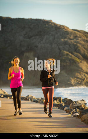 Zwei Frauen Lauf am Meer Stockfoto