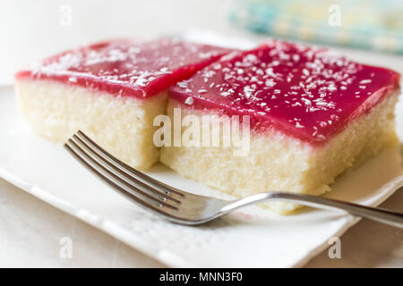 Türkische Muhallebi Grießbrei Dessert Pudding mit Gelee Himbeer und Kokosnuss Pulver/Trilece. Traditionelle Dessert. Stockfoto