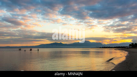 Fischer werfen ihre Netze in den Pazifischen Ozean, als die Sonne an einem schönen, tropischen Strand erhebt sich auf der Insel der Fidschi-inseln im Südpazifik. Stockfoto